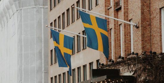 a couple of flags hanging from the side of a building